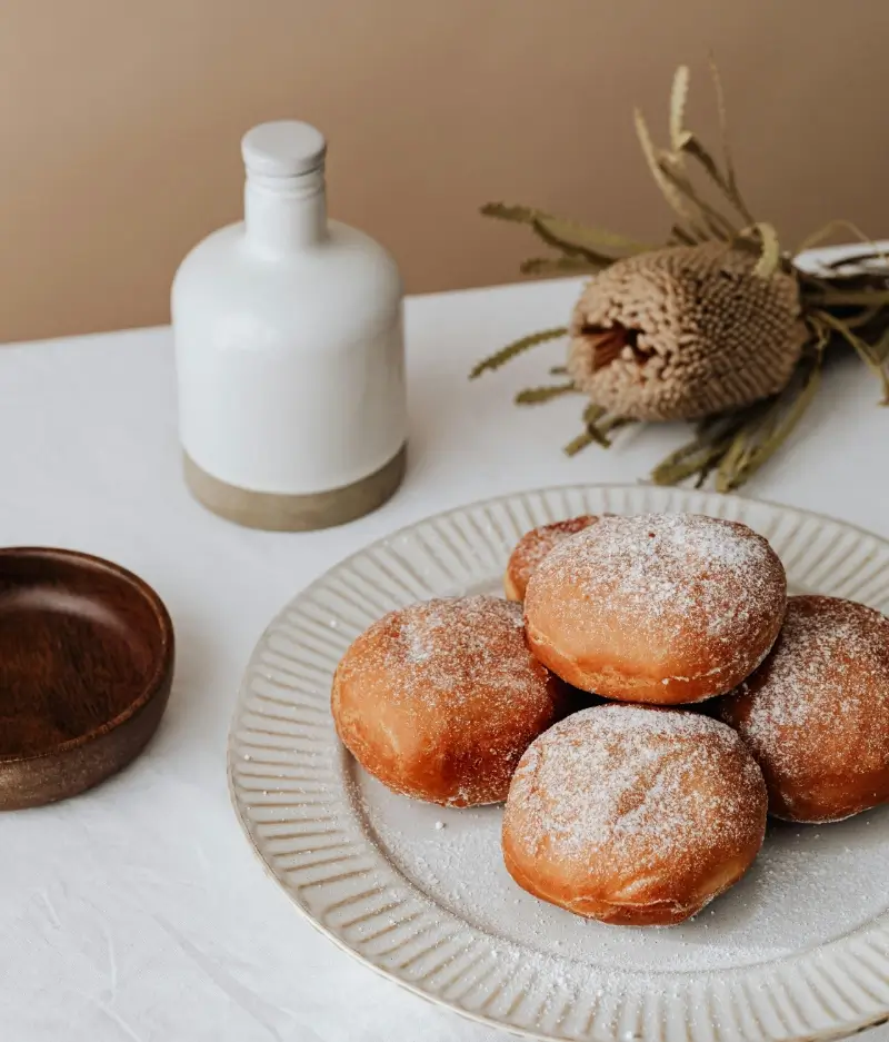 A plate filled with donuts on a white table